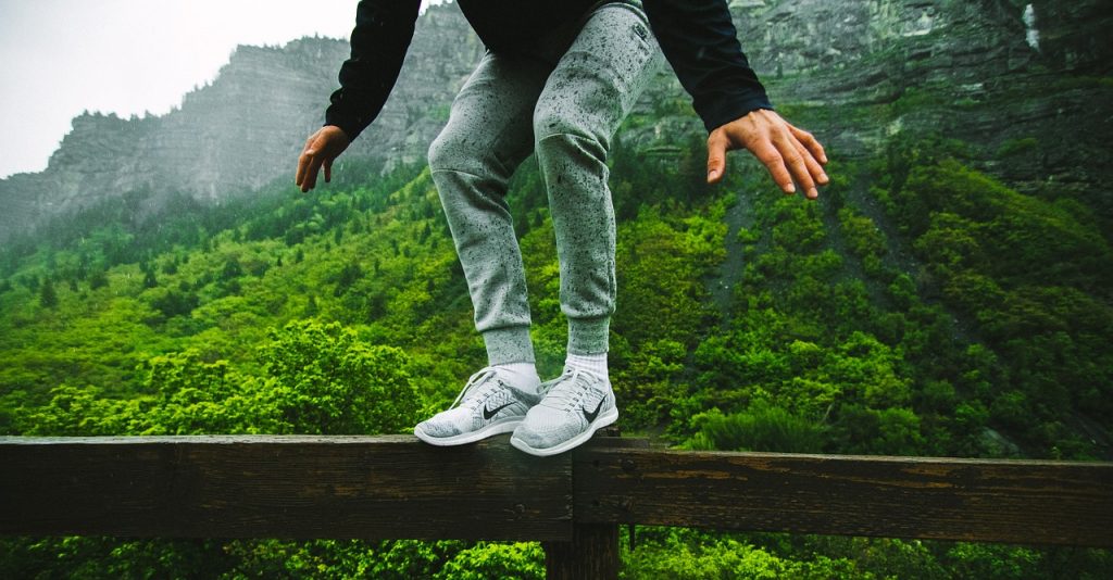 Der Körper in der Meditation. Ein Mensch balanciert auf einem Geländer. Er ist ganz im Körper.